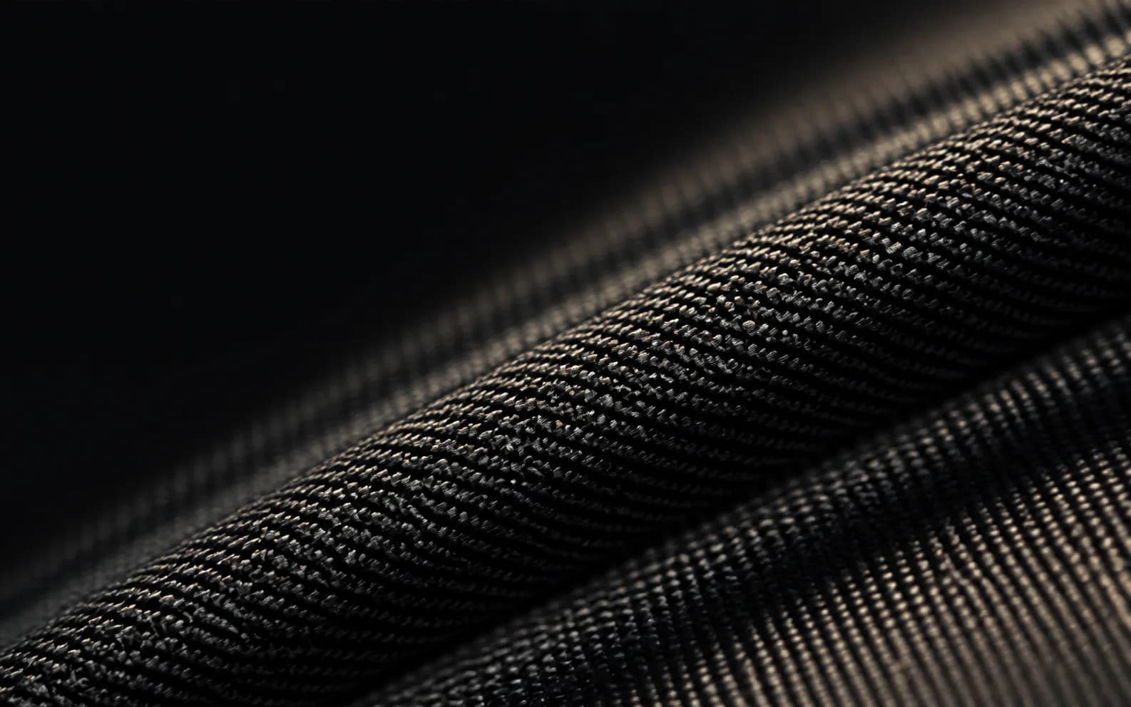 Macro view of a dark engineered textile with a precise woven structure